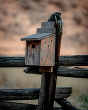 Vertical Shot Of A Wooden Birdhouse On A Fence