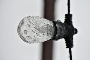 Wall Mural - Close-up low angle shot of a frozen lamp outdoor on a blurred background