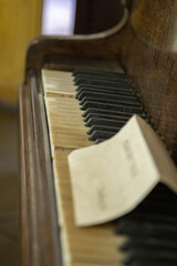 Sticker - Vertical shot of a note left on a dusty old broken piano