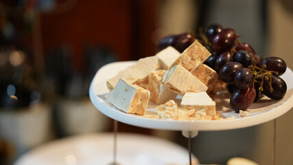 Sticker - Closeup of the plate with black grapes and white chocolate with nuts.