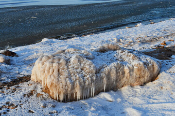 Sticker - Vertical shot of frozen snowy stones on a seashore