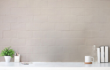 Wall Mural - Comfortable workplace with houseplant, coffee cup, books and pencil holder on white table.