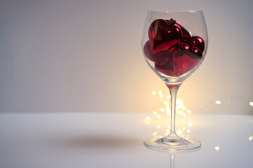 Poster - Closeup shot of transparent glass full of heart-shaped toys on a reflecting surface