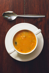 Canvas Print - Vertical top view of a bowl of vegetable soup with sausage