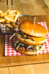 Canvas Print - Appetizing burger with French fries on a wooden board