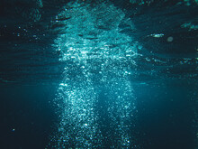 Underwater Shot Of Sun Rays Going Through Deep Ocean Making Water Bubbles