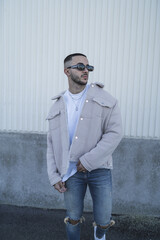 Canvas Print - Stylish handsome Spanish man wearing a beige coat with sunglasses outdoors