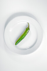 Sticker - Vertical shot of a green pepper on the white plate