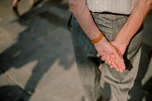 Elderly Man With His Hands Behind His Back Wearing A Watch And Wedding Ring