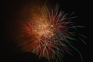 Poster - Low angle shot of festive fireworks bursting in night sky with colorful sparks