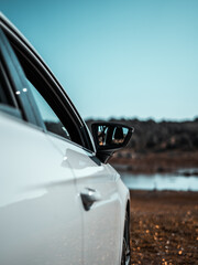 Canvas Print - Closeup of a side mirror of a white luxury car in a field