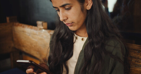 Poster - Young South Asian female looking at her phone