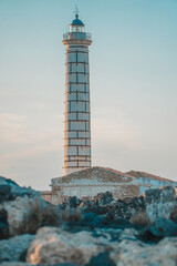 Wall Mural - Vertical shot of the lighthouse of Punta Cavazzi in Ustica, Italy against a colorful evening sky