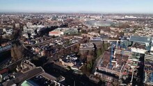 Orbiting drone shot of Dublin City. This urban landscape has a beautiful blue sky with clusters of buildings and a great view of Aviva stadium from behind.