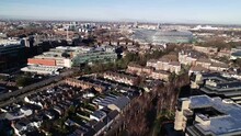 Beautiful establishing drone shot of Dublin City with clusters of buildings and a view of the Aviva stadium from the back.