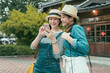 © PR Image Factory - Two happy attractive female friends sharing smart phone discussing next tourist destination on internet in sunny street park. smiling girls looking online map together in mobile phone while traveling