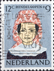 Wall Mural - Netherlands - circa 1960: a postage stamp from the Netherlands , showing a child with a traditional Hindeloopen costume