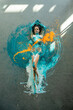bodypainting woman, expressive sexy young elegant on the floor in turquoise, blue and orange color abstractly painted, surrounded by light spots, abstract body art painting