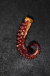 phalanx of grilled octopus on a dark background