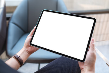 Wall Mural - mockup image of a woman holding digital tablet with blank white desktop screen in cafe