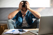 © tai - Serious upset young man entrepreneur at home works on a laptop computer and online checks no orders to pack the parcel, cause customers cancel, Unsuccessful Selling shopping, and bad business ideas
