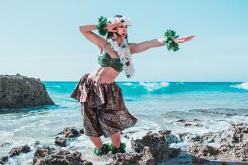 Wall Mural - Hawaiian woman enjoys hula dancing on the beach barefoot wearing traditional costume