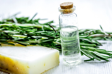 Wall Mural - cosmetic oil in bottle with herbs on light table background