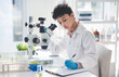 © Allistair/peopleimages.com - What she finds she records. Cropped shot of an attractive young female scientist making notes while working with a microscope and plants in a laboratory.
