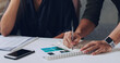 © Emil L/peopleimages.com - Making a few notes. Cropped shot of two unrecognizable businesspeople working together in the office.