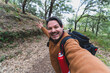 Autoretrato tipo selfie de un chico gordo en sendero de ruta verde con paisaje de bosque