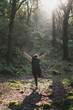 © MiguelAngelJunquera - Chica joven guapa de espaldas poniendo poses par ala fotografía con el sol de fondo en un bosque lleno de niebla