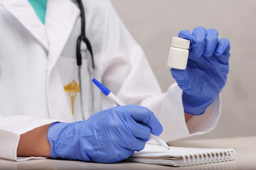 Medicine bottle mockup. a doctor's hand in a blue disposable glove holding a white plastic bottle with medicine.