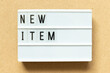 Lightbox with word new item on wood background