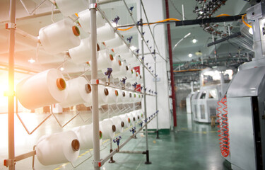 Textile industry - yarn spools on spinning machine in a textile factory