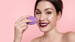 © deniskomarov - Happy young woman hold lavender sponge for applying makeup foundation on face. Female use cosmetics for trendy make up, healthy complexion, glowing skin tone.