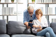 © offsuperphoto - senior couple, elderly man and woman using tablet on sofa