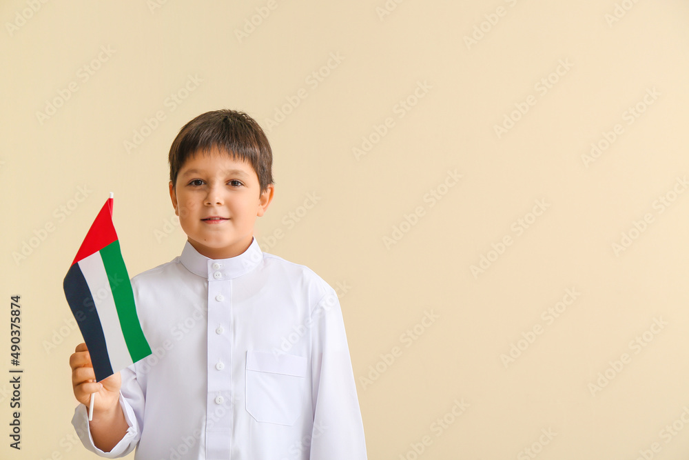 Cute little boy with national flag of UAE on light background