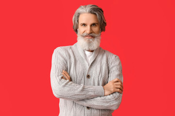 Sticker - Handsome senior man in knitted sweater on red background