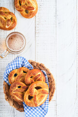 Wall Mural - Bavarian pretzels and glass of lager beer. Oktoberfest food menu, traditional salted pretzels over old white wooden background. Top view with space for text. Oktoberfest theme