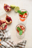 Fototapeta Kuchnia - Glasses of tasty pomegranate cocktail on white background