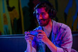 © SuperStock - Video game streamer in his room with colored lights and game controller.