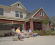 © SuperStock - Group of male middle aged Friends hanging out in driveway, tailgating from home