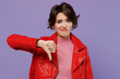 Young displeased disappointed sad woman 20s wearing red leather jacket showing thumb down dislike gesture isolated on plain pastel light purple background studio portrait. People lifestyle concept