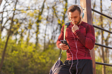 Wall Mural - Man using smart phone after outdoor workout