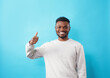 © Tatsiana - Young african american man wearing casual clothes smiling happy and positive, thumb up doing excellent and approval sign.