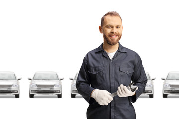 Wall Mural - Mechanic in front of silver cars holding a wrench