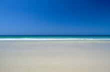 Calm Tropical Water Meets Blues Sky And Pristine Sandy Beach