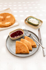 Wall Mural - Pancakes served on a plate with sour cream and berry jam