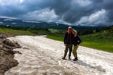 A girl with a man on a glacier on the snowy plateau of Lagonaki in Adygea. Russia. 2021.