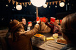 © StratfordProductions - Group of diverse friends sitting, making a toast at an outdoor party around a boho themed table. Red cups and laughs